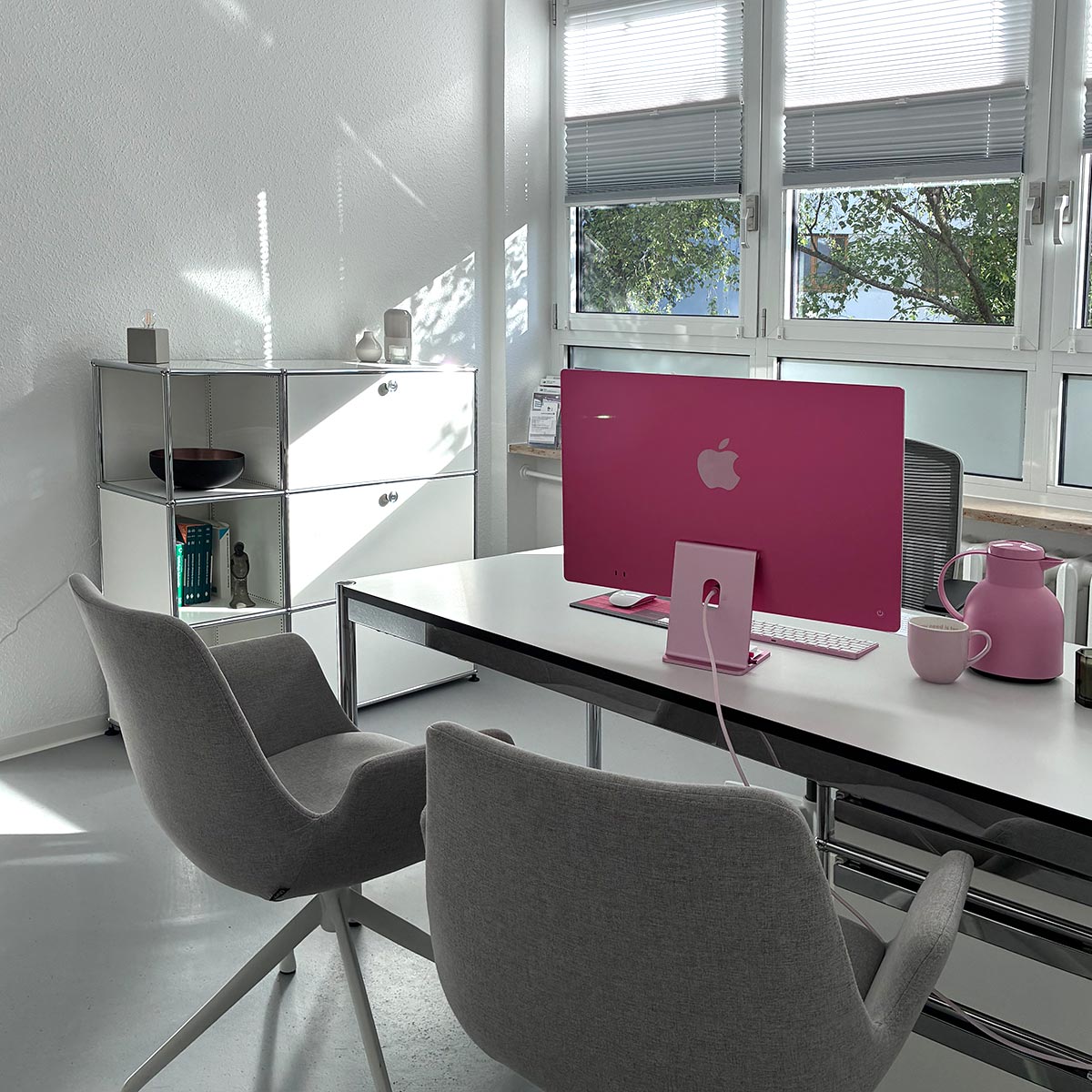 Arztzimmer mit weißen Möbeln und rosa Computer